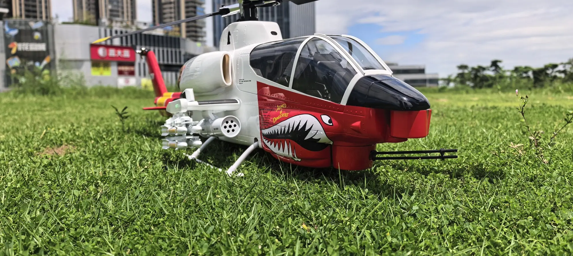 FLISHRC AH-1 Cobra white and red RC helicopter front three-quarter view outdoors